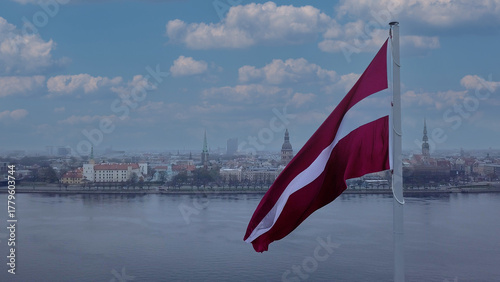 Drone View Of Riga Old Town With Latvian Flag Waving In Foreground Aerial Panorama Of Historic City Center, Daugava River And Urban Skyline On A Outumn Day In Latvia