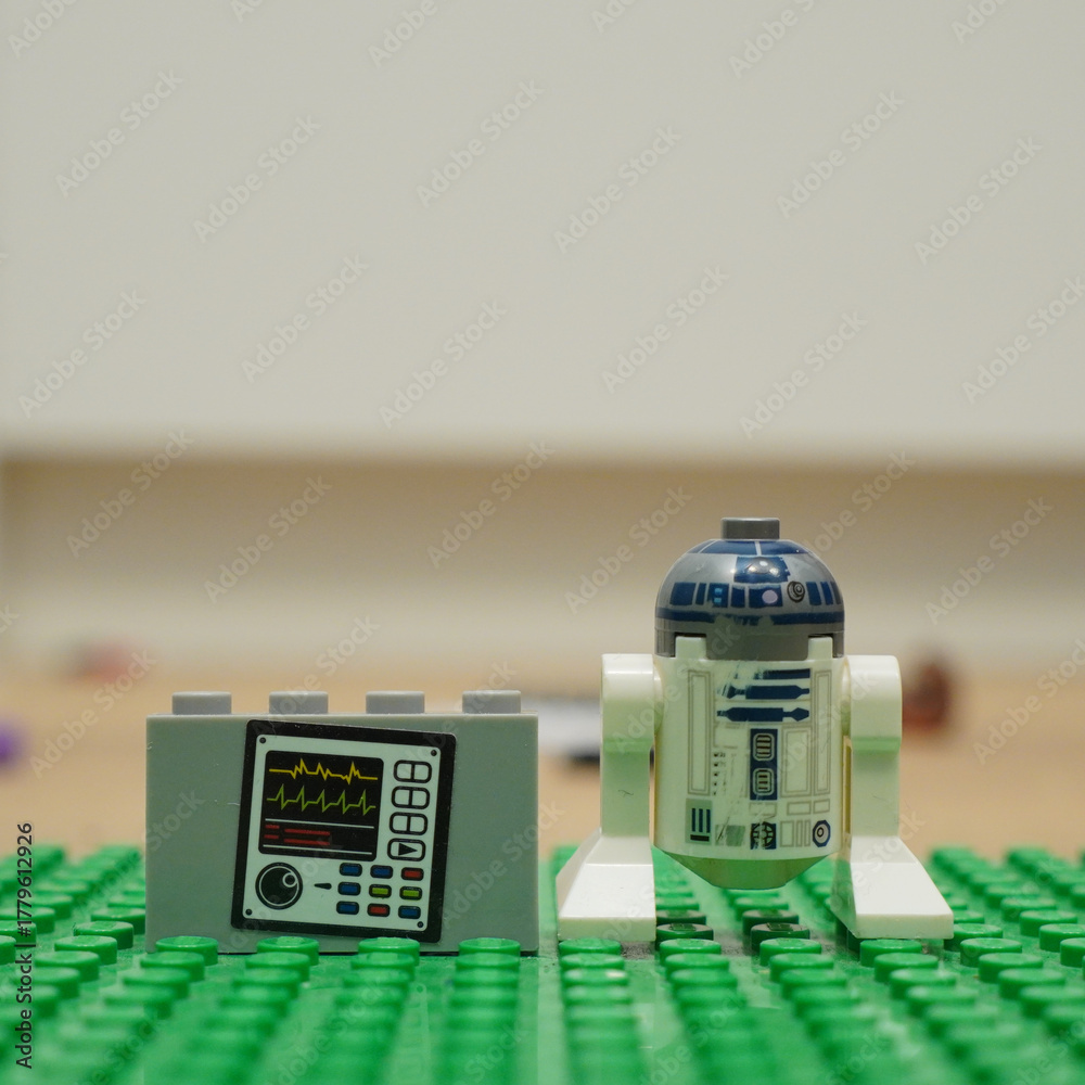 Naklejka premium Lego R2-D2 and medical equipment on a green baseplate