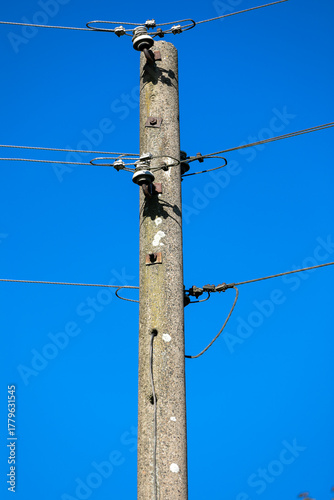 Ein Hochspannungsmast aus Beton mit Stromleitungen in zwei Richtungen