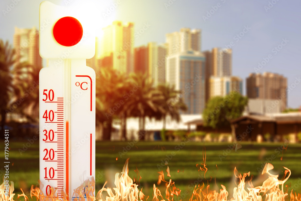 Fototapeta premium Thermometer showing high temperature against city during hot day