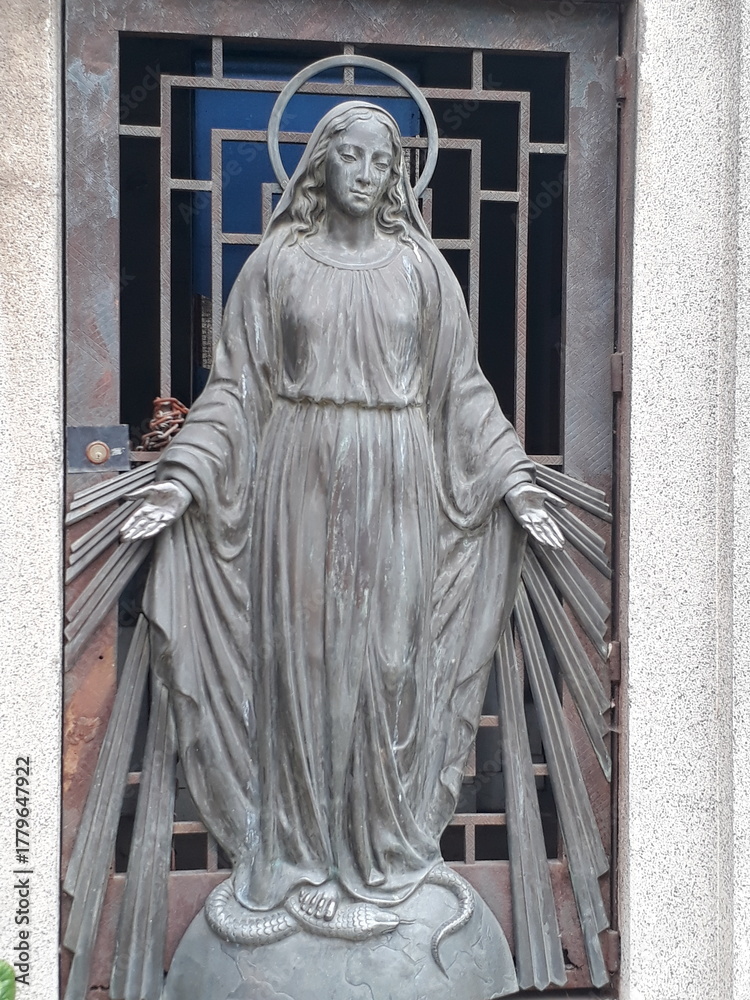 Φωτογραφία Escultura de una imagen religiosa sobre sepultura en un cementerio