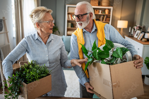 Senior couple moving, unpacking boxes in new home