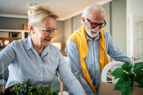Senior couple packing moving boxes downsizing home