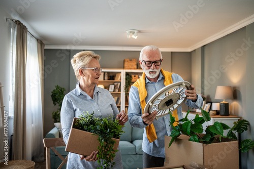 Photos Senior couple unpacking items while moving into new home