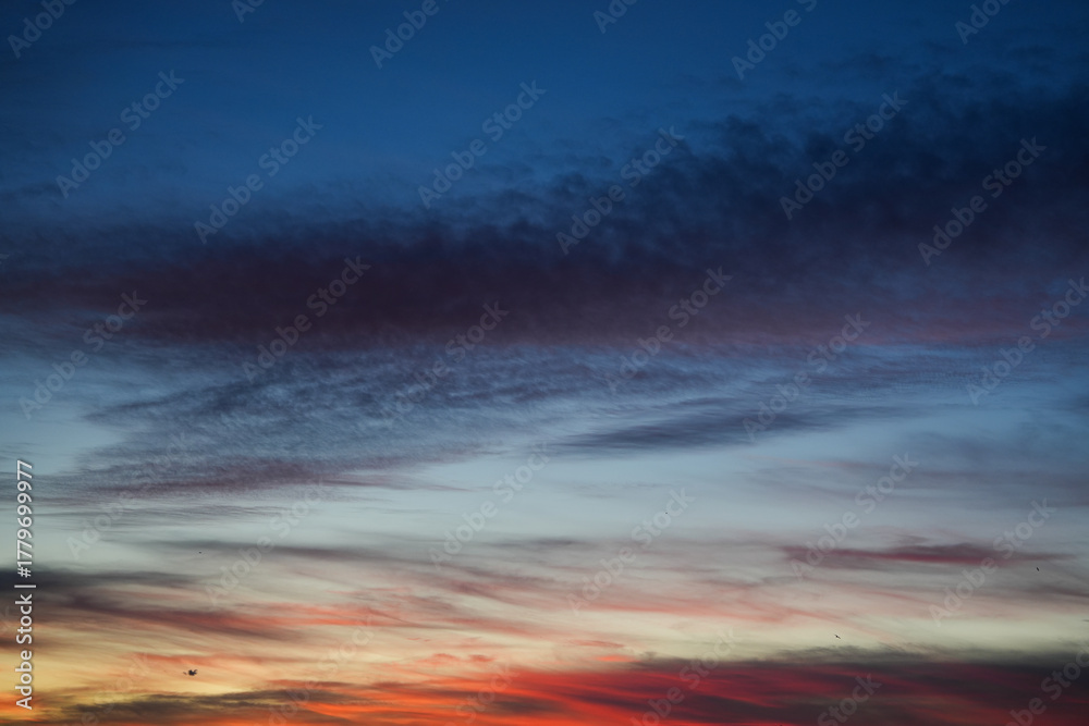 Obraz premium Evening sky with soft clouds and warm gradient tones during sunset creating abstract pattern