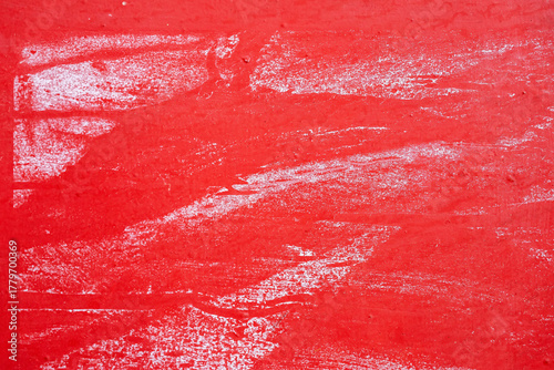 Fototapeta Naklejka Na Ścianę i Meble -  Rough red wall with scraped white paint marks and textured surface. Abstract distressed background and worn painted texture. Copy space