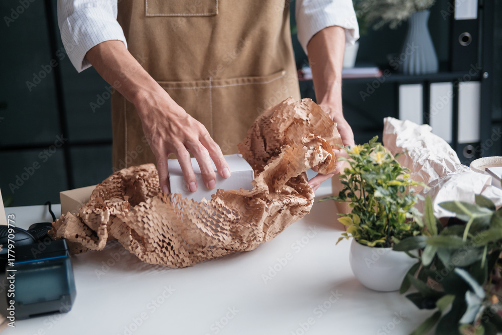 Obraz premium startup entrepreneur packs online order in recyclable cardboard box for eco-conscious customer