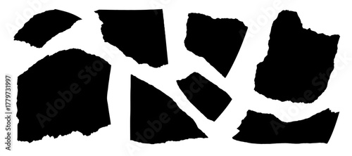 black paper scraps scattered on a white background surface view.