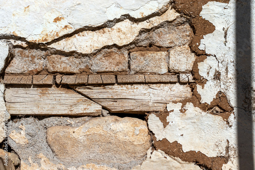 Stone masonry, adobe plaster, wooden flooring detail, damaged in the earthquake.