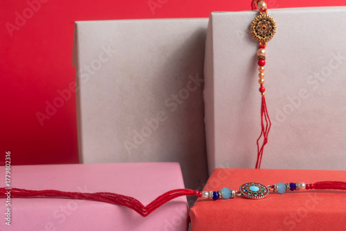 Festive gift boxes with beaded rakhi bangles on a red background - decorative gift arrangement