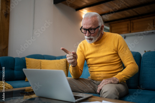 Senior man having video call, expressing strong opinion