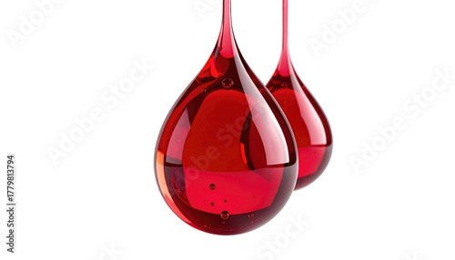 Two red liquid drops hang, illuminated against a black background, showing internal bubbles and light play