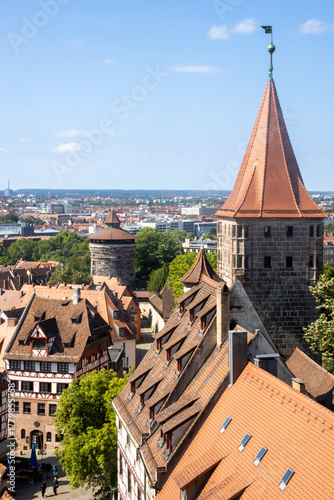 Panoramic view of Nuremberg's old town from Kaiserburg Nuremberg, featuring Bavarian timber-framed houses, medieval towers, and red rooftops under a clear summer sky.