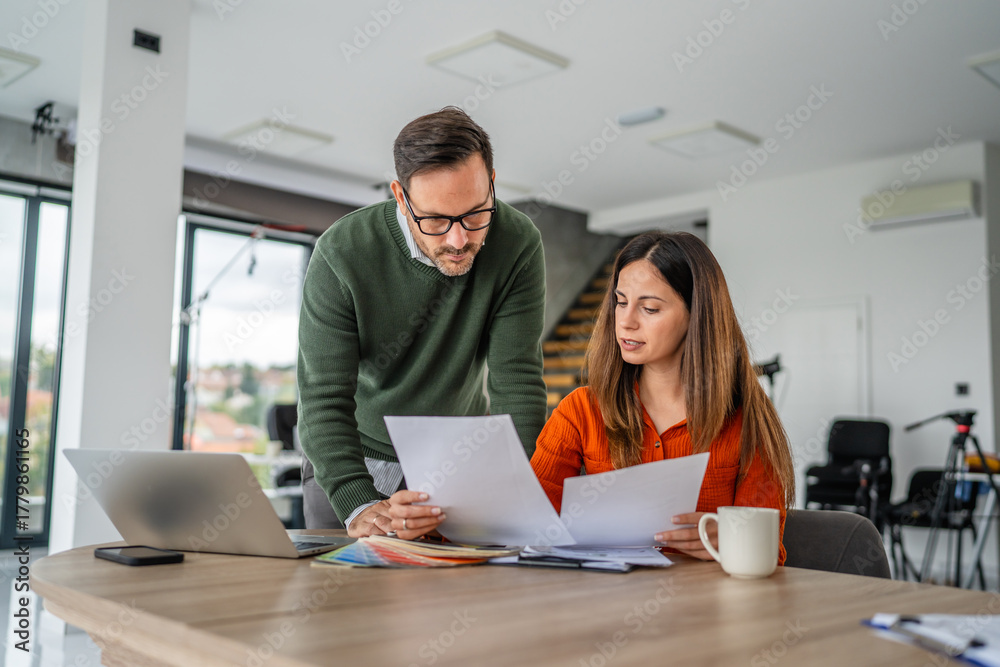 Fototapeta premium Coworkers collaborating on business project reviewing documents in office
