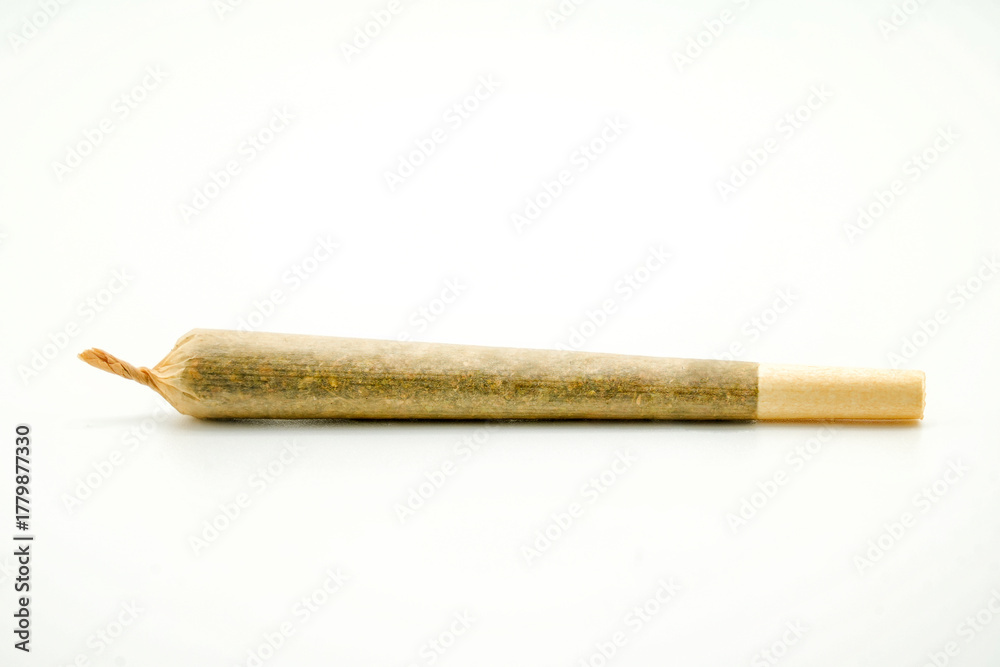 Obraz premium A joint after rolling, with a paper filter at left marijuana cigarette. Joint rolled cannabis cigarette, Prerolled Stick real photo white background