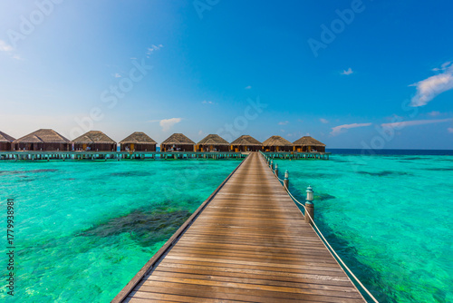 Fototapeta Naklejka Na Ścianę i Meble -  Wooden deck goes to bungalows. Tropical island beach landscape exotic shore coast. Tranquil closeup calm sea water waves. Summer vacation, holiday amazing nature. Relax paradise, Maldives.