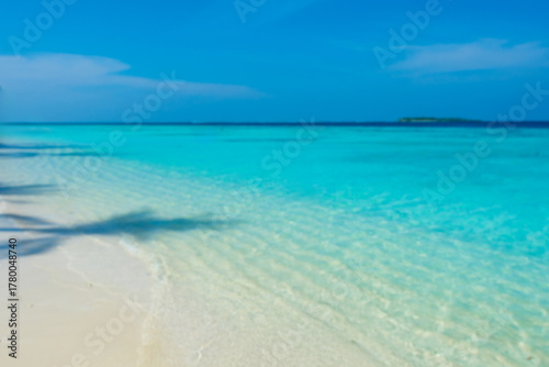 Fototapeta Naklejka Na Ścianę i Meble -  Tranquil closeup calm sea water waves with palm trees. Tourist posing in front of bungalows. Tropical island beach landscape exotic shore coast. Summer vacation, holiday amazing nature, Maldives.