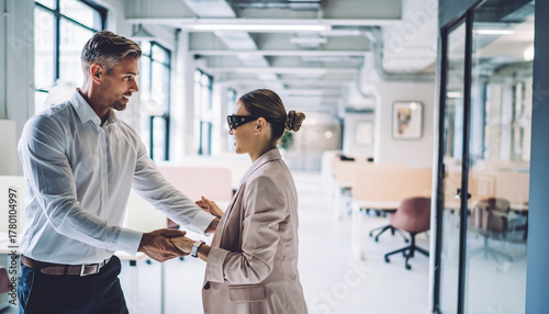 Wallpaper Mural Coworker assisting blind colleague crossing modern office aisle, supportive teamwork, inclusive workplace, professional attire, bright open workspace, positive interaction Torontodigital.ca
