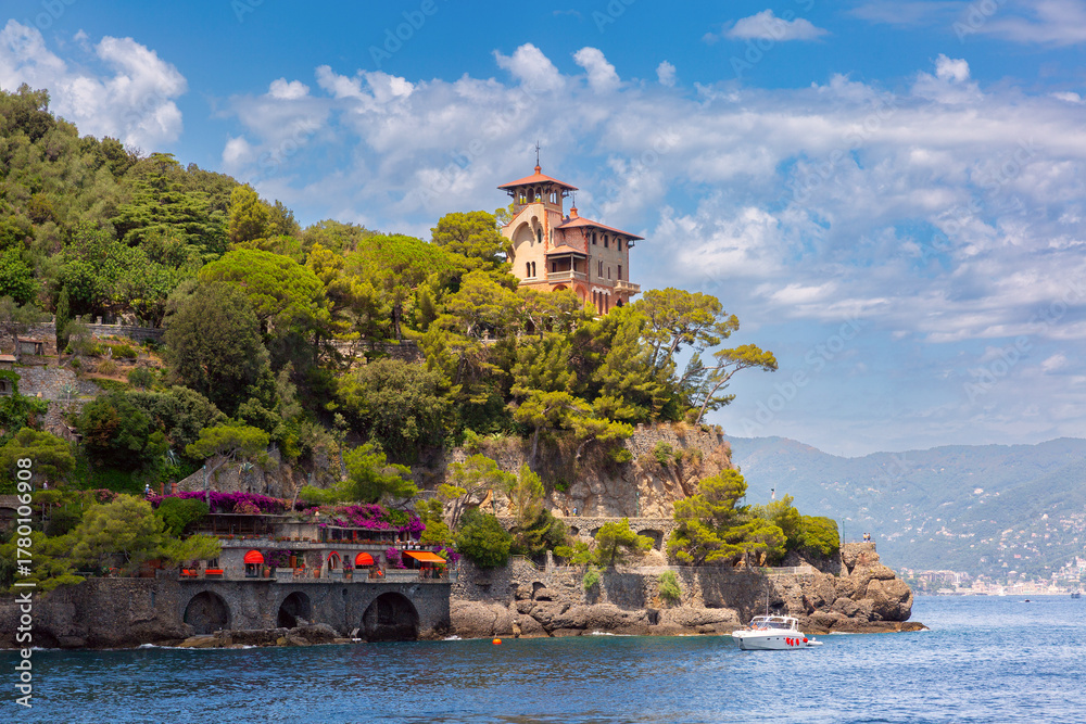 Obraz premium Seaside villa on rocky cliff surrounded by trees in Portofino, Italy, Liguria region