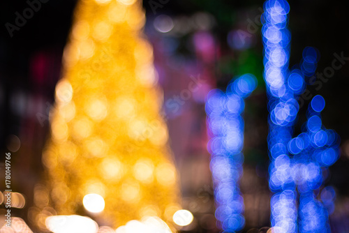 Bokeh lights abstract background gold blue. A vibrant holiday composition featuring large, blurred circles of warm golden lights forming a Christmas tree shape and vertical lines of cool blue