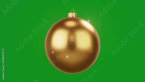 A shiny golden Christmas bauble against a vibrant green screen background, perfect for holiday season projects.