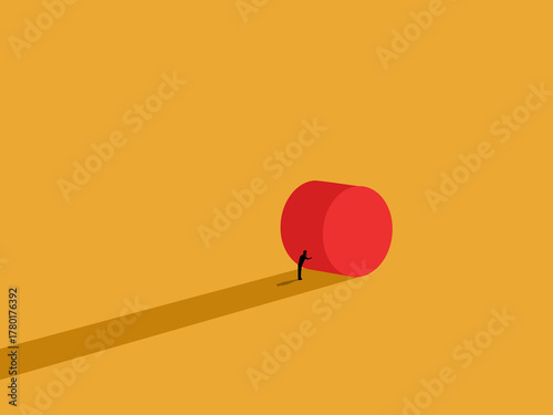 Working easy, a businessman tries to push a round object.