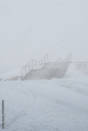 Outdoor Stairs in Winter Fog Leading to Unknown Destination.