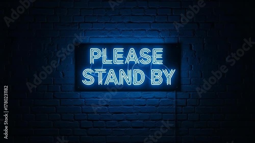 Neon Please Stand By Text Sign Glowing Brightly on Dark Brick Wall Closeup