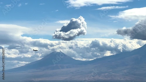An airplane landing during the day, an airplane against the backdrop of Mount Ararat, an airplane over the city from the side view. High quality 4k