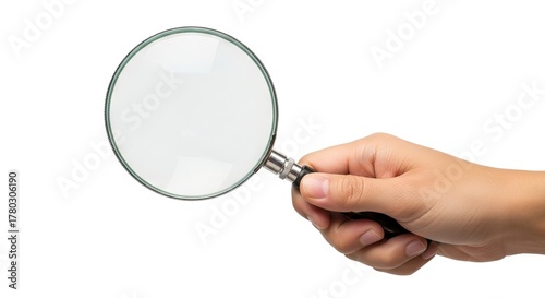 A hand holds a magnifying glass with a silver and black handle against a white background