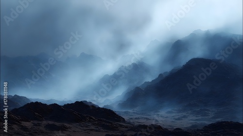 Dramatic mountain landscape shrouded in atmospheric fog and mist showcasing rugged barren terrain under a dark sky