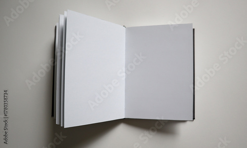 Konstfotografi An open sketchbook showing two blank white pages on a neutral light gray background
