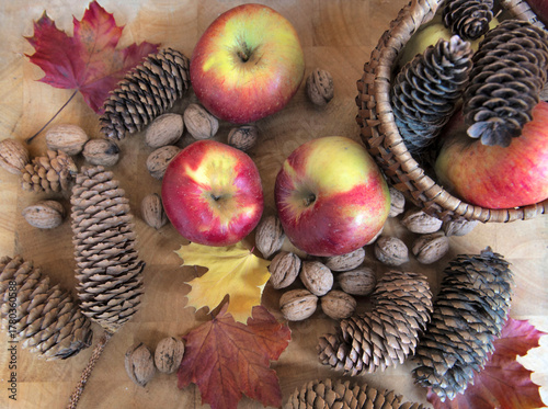 top view on bright red apples, walnuts and autumnal leaf on wooden background...