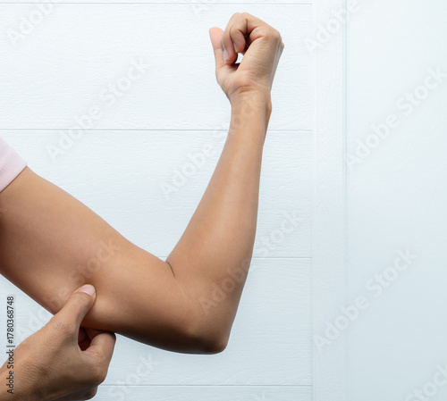 Fotografie Skin fat hand woman concept,people pinching a fat on arms,fitness diet young lifestyle, authentic skin tan asian, saggy muscle and excess fat,close Up slim fit body, shapely girl and health