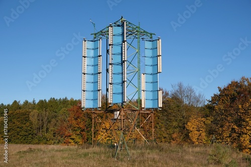 A vertical axis wind turbine (VAWT) on field in Kashubia, Poland, in autumn scenery and blue sky.