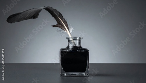 Feather quill resting on glass ink bottle with gradient gray background