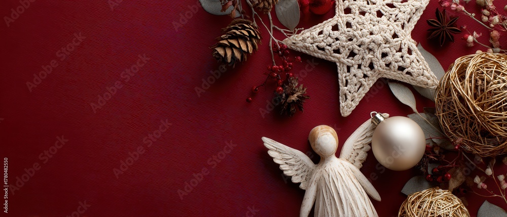 Obraz premium Elegant Christmas Decoration with Angel Figurine, Star Ornament, and Pine Cones on Red Background for Festive Holiday Season