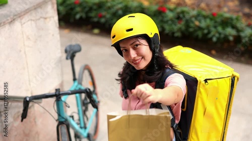 Female courier with a thermal backpack delivering an order