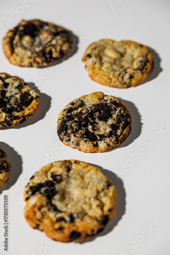A close-up view of cookies baked with crushed chocolate sandwich cookies on a clean white background, showing texture and golden edges. No visible branding