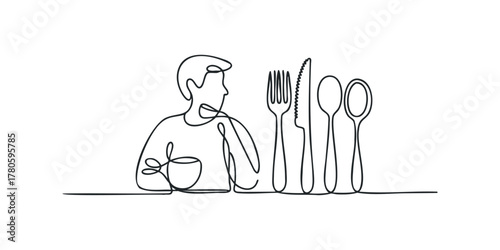 Man holding cup and cutlery on table