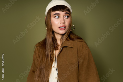 Charming young woman in stylish brown jacket and cream beanie for a trendy urban look
