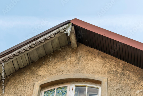 Bild auf Leinwand Renovation replaces old roof slope with modern metal panels and highlights loss of historic detail and cultural heritage