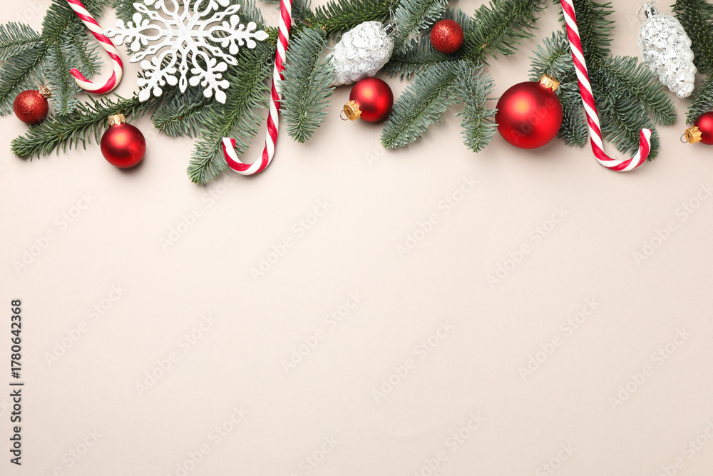 Naklejka premium Fir tree branches, candy canes and Christmas decor on light background, flat lay. Space for text