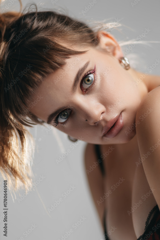 Naklejka premium Portrait of a Young Woman with Expressive Blue Eyes