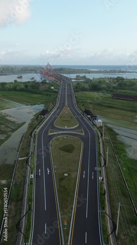 Special Region of Yogyakarta, Indonesia - October 15, 2025 : Aerial View Of Long Orange Arch Bridge Under Construction Over Wide River Landscape