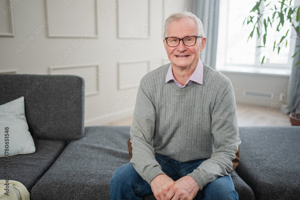 Fototapeta premium Portrait of confident stylish European middle aged senior man at home. Older mature 70s man smiling. Happy attractive senior grandfather looking camera close up face headshot portrait. Happy people