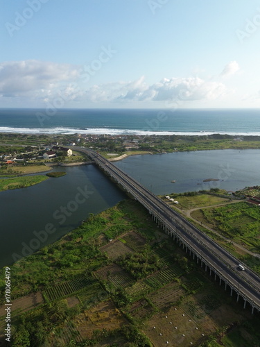 Wallpaper Mural Special Region of Yogyakarta, Indonesia - October 15, 2025 : Aerial View Of Coastal Town With Bridge Over Water And Green Fields Torontodigital.ca