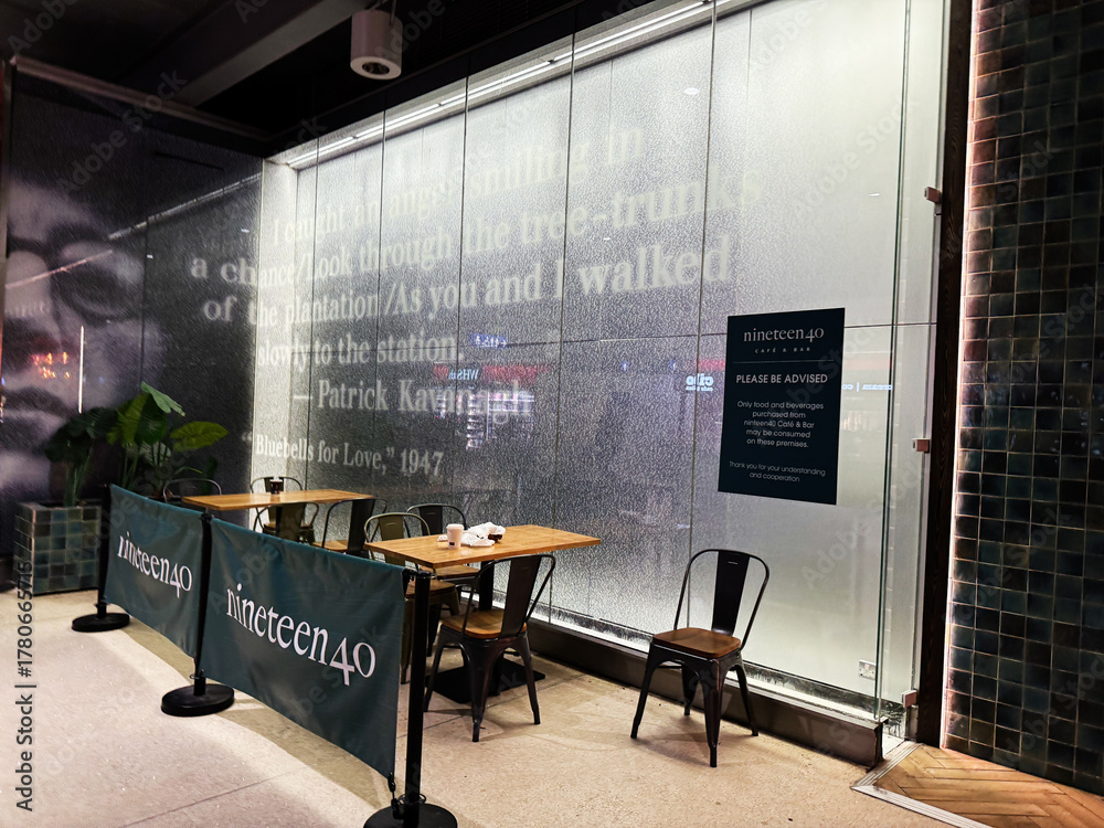 Fototapeta premium Cafe seating at nineteen40 in Dublin, Ireland with frosted glass wall art and branding