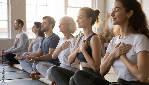 Group of Diverse People Practicing Meditation in Yoga Class with Natural Light