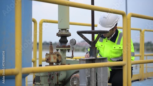 Engineer inspecting valves and monitoring system operation at wastewater treatment plant, focusing on clean water purification, recycling, and sustainable industrial water management.